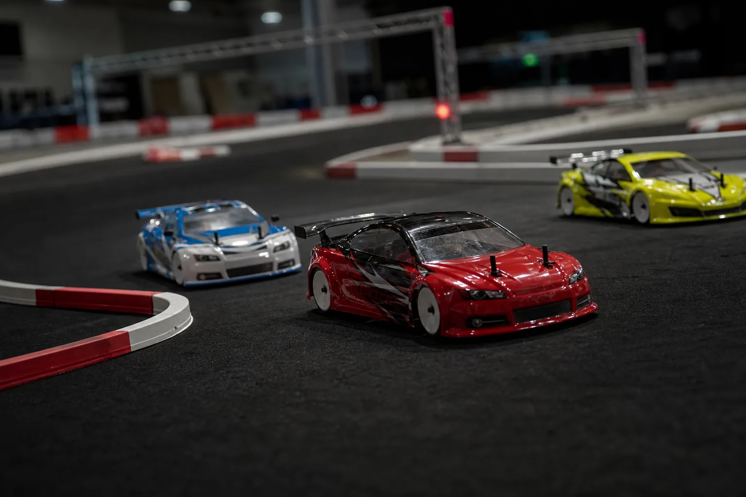 Three physical RC touring cars racing on The Grid's indoor circuit